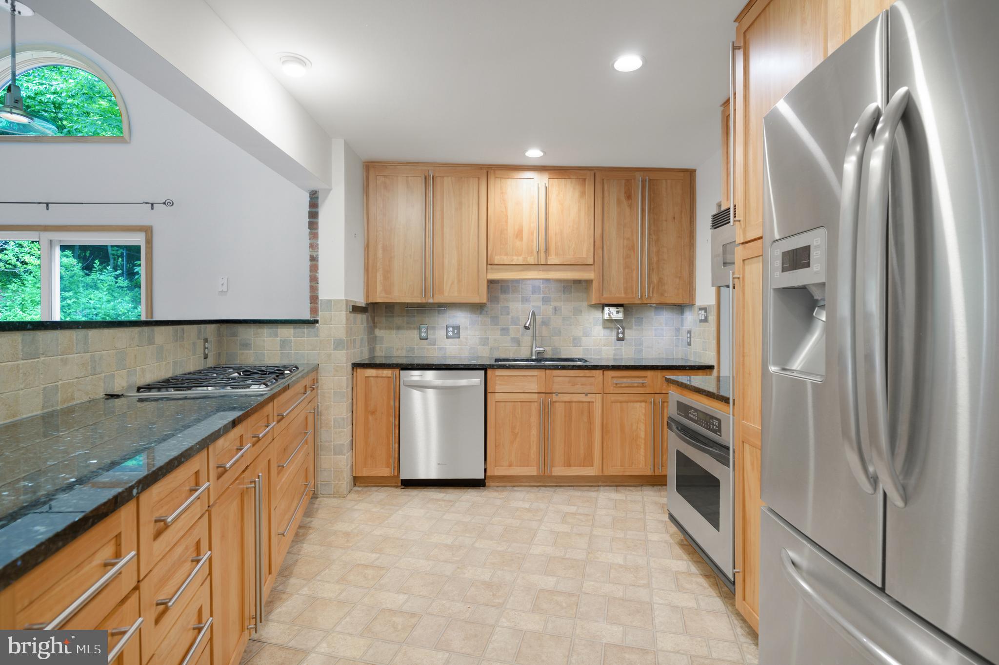 3111 North Thomas Street Arlington, VA 22207 - Photo 9 of 40 a kitchen with stainless steel appliances granite countertop a refrigerator and a stove top oven