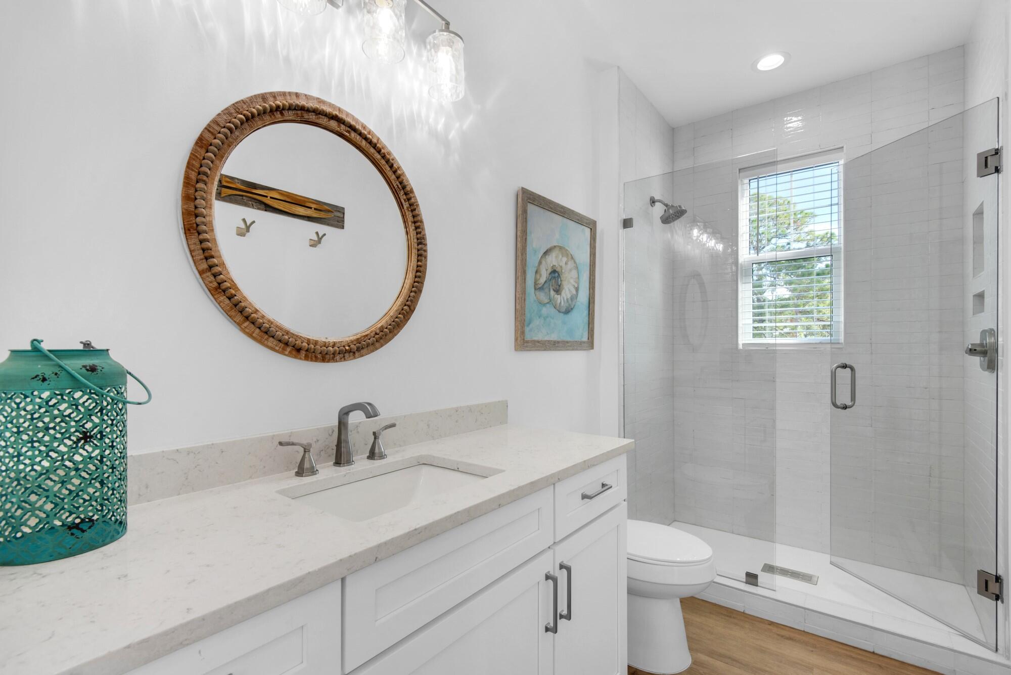 6528 West County Highway 30A Santa Rosa Beach, FL 32459 - Photo 15 of 87 a bathroom with a toilet a sink and a mirror