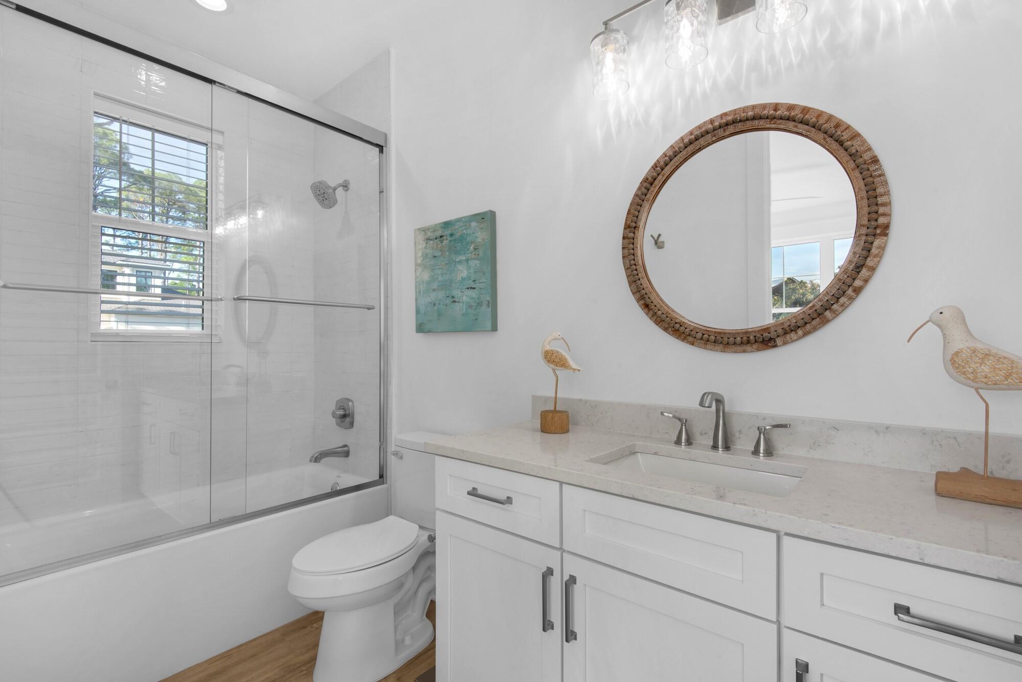 6528 West County Highway 30A Santa Rosa Beach, FL 32459 - Photo 18 of 87 a bathroom with a sink a toilet and a mirror