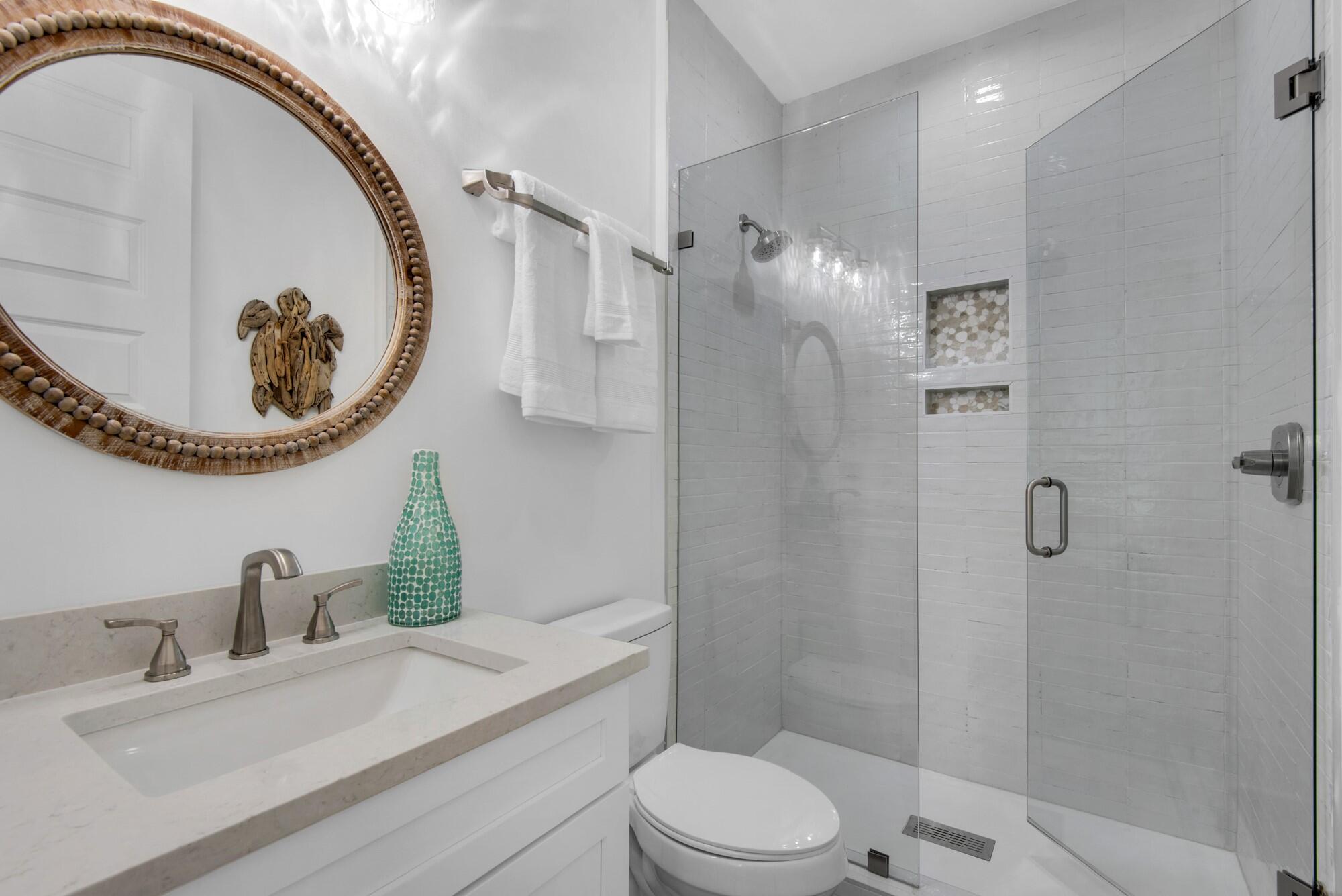 6528 West County Highway 30A Santa Rosa Beach, FL 32459 - Photo 21 of 87 a bathroom with a toilet a sink and mirror