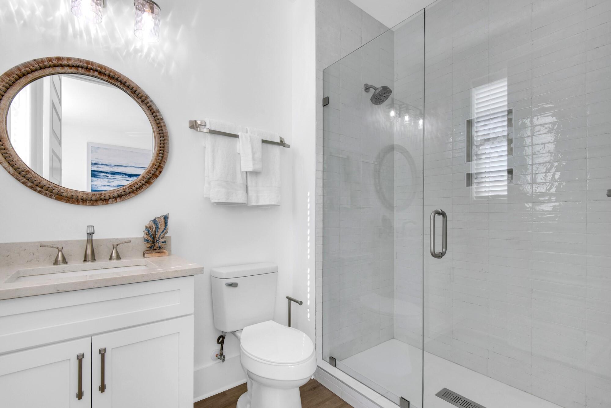 6528 West County Highway 30A Santa Rosa Beach, FL 32459 - Photo 24 of 87 a bathroom with a sink a toilet and a mirror