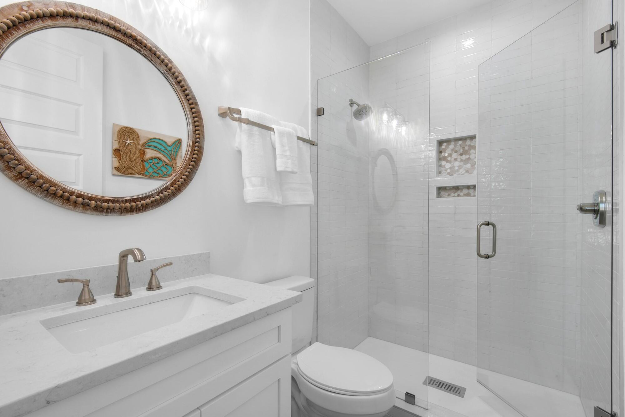 6528 West County Highway 30A Santa Rosa Beach, FL 32459 - Photo 34 of 87 a bathroom with a sink a toilet and a mirror