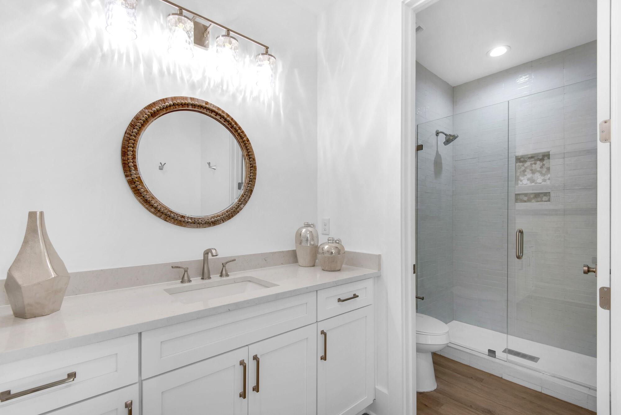 6528 West County Highway 30A Santa Rosa Beach, FL 32459 - Photo 37 of 87 a bathroom with a sink a toilet and a mirror