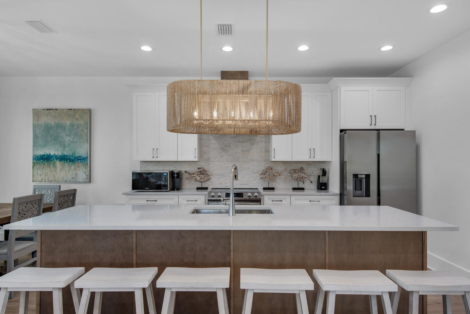 6528 West County Highway 30A Santa Rosa Beach, FL 32459 - Photo 8 of 87 a kitchen with a table chairs refrigerator and microwave