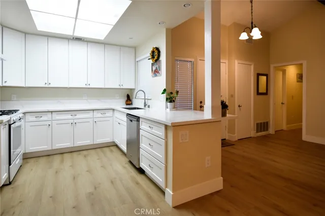 a kitchen with a sink cabinets and wooden floor