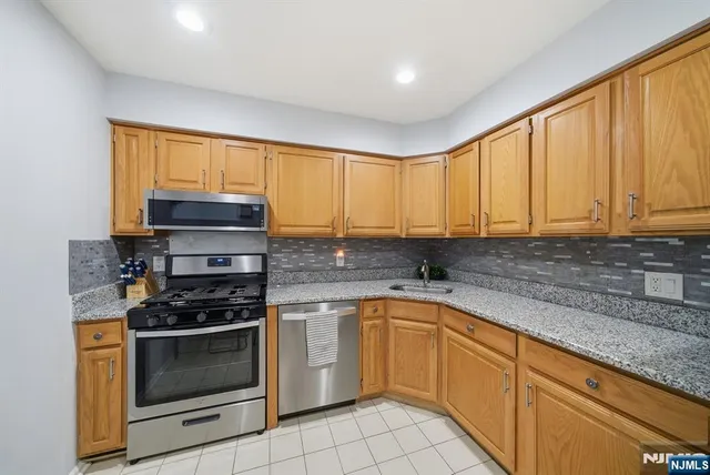 a kitchen with stainless steel appliances a stove sink and cabinets