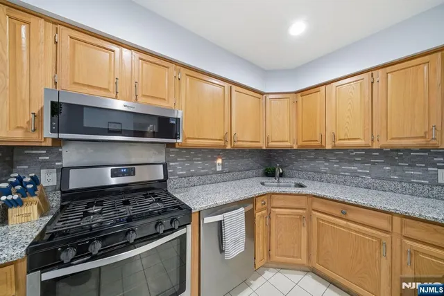 a kitchen with granite countertop a stove sink and cabinets