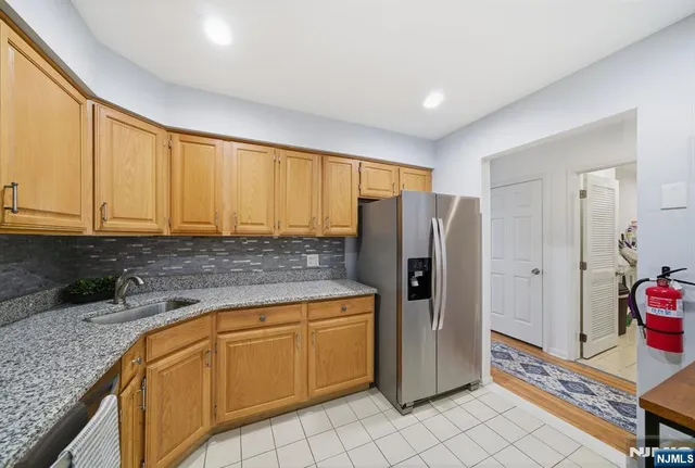 a kitchen with stainless steel appliances granite countertop a refrigerator and a stove top oven