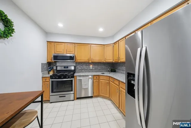 a kitchen with stainless steel appliances granite countertop a refrigerator and a stove top oven
