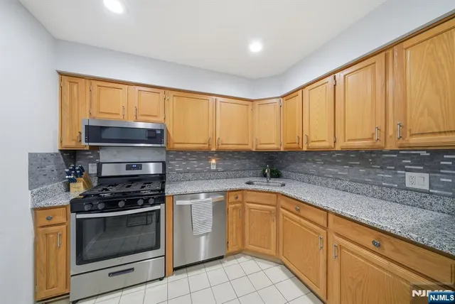 a kitchen with granite countertop a stove sink and cabinets