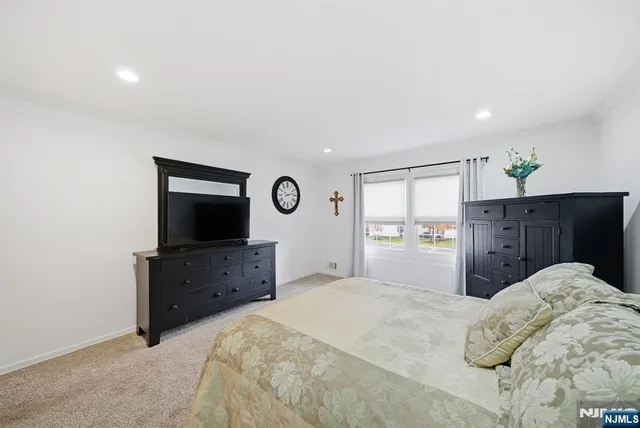 a bedroom with a bed and a flat screen tv in a dresser