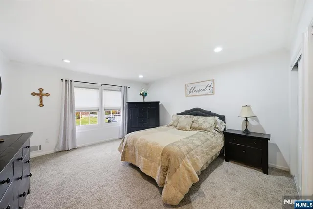 a spacious bedroom with a bed and a window