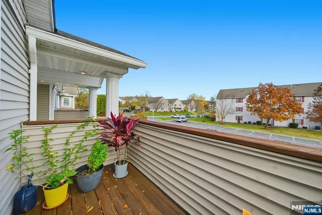 a vase of flowers sitting on a floor with a potted plant