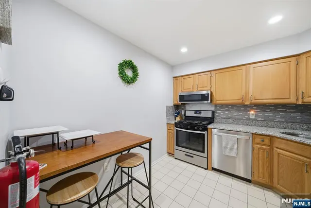 a kitchen with stainless steel appliances granite countertop a stove a sink dishwasher and a microwave