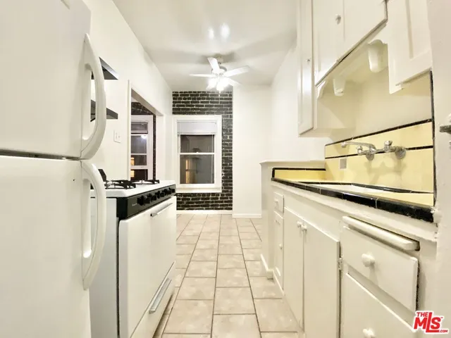a kitchen with stainless steel appliances a stove refrigerator and cabinets