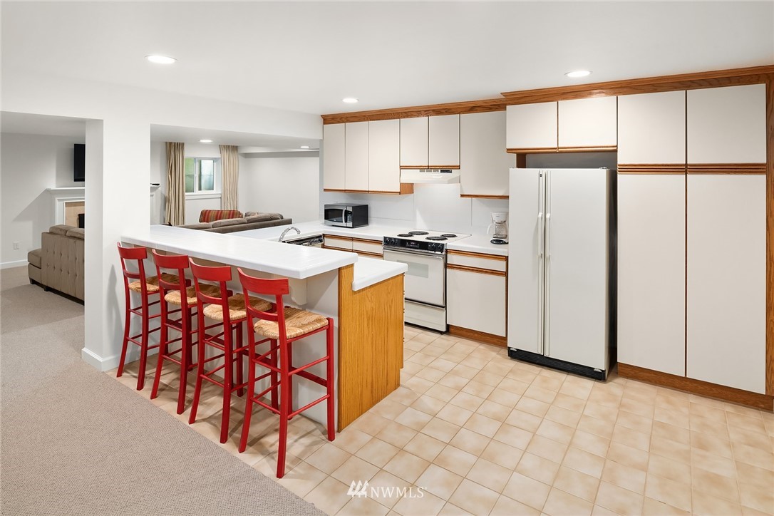 142 Moss Road Shoreline, WA 98177 - Photo 21 of 32 a kitchen with stainless steel appliances a refrigerator a stove a sink and white cabinets