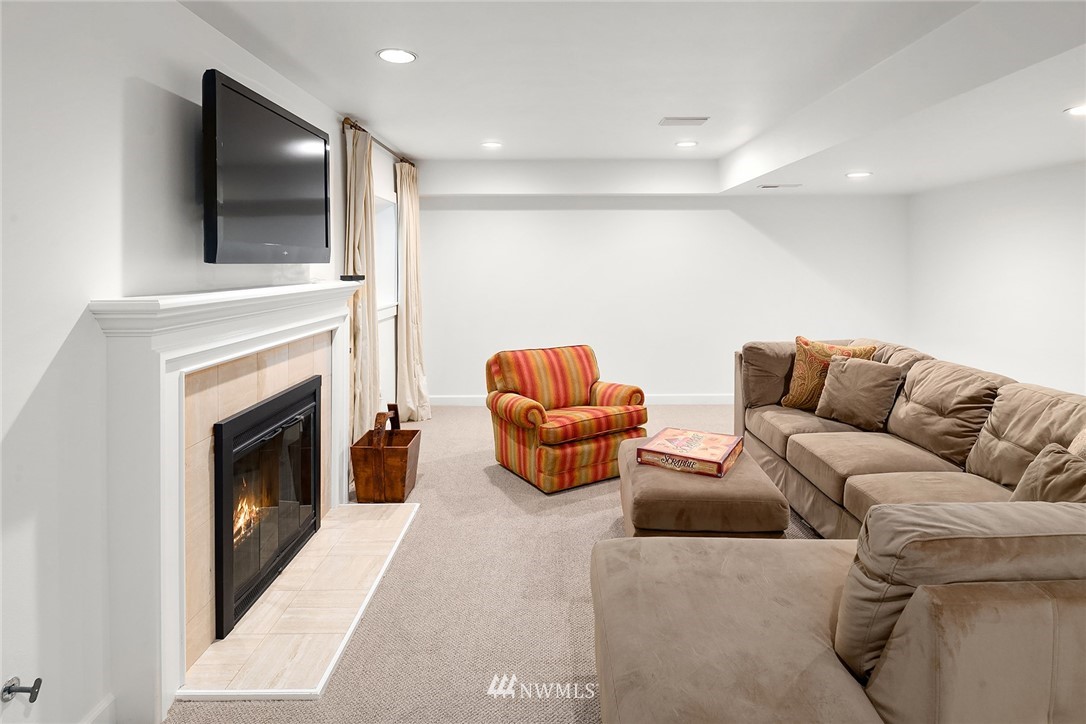142 Moss Road Shoreline, WA 98177 - Photo 22 of 32 a living room with furniture a flat screen tv and a fireplace