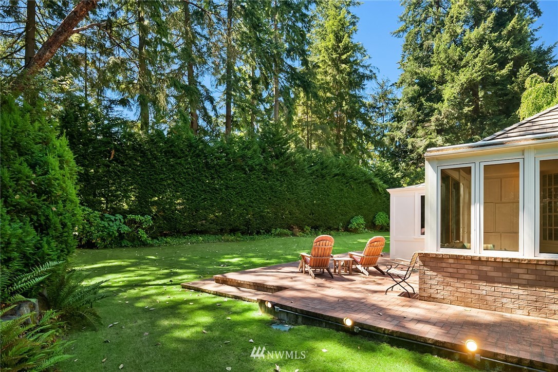 142 Moss Road Shoreline, WA 98177 - Photo 27 of 32 a view of a backyard with table and chairs and potted plants with large trees