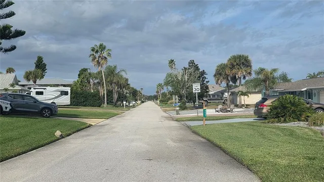 a front view of a house with a yard and potted plants