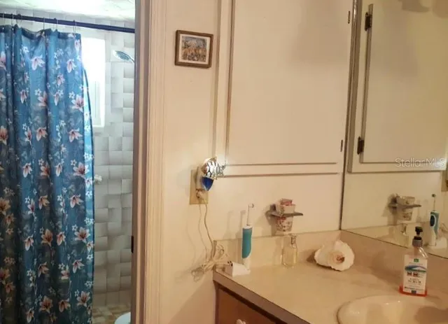 a bathroom with a granite countertop shower and a sink