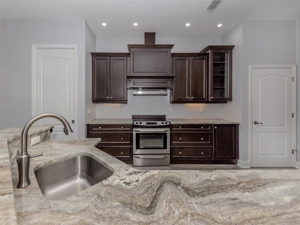 2107 Johannesberg Road North Port, FL 34288 - Photo 12 of 60 a kitchen with stainless steel appliances granite countertop a stove and a sink with granite countertops
