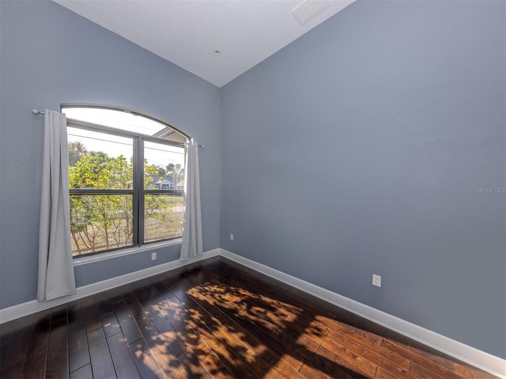 2107 Johannesberg Road North Port, FL 34288 - Photo 14 of 60 an empty room with wooden floor and windows