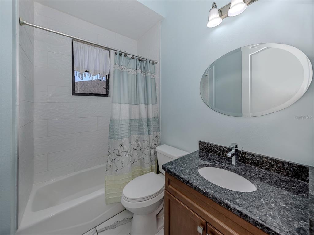 2107 Johannesberg Road North Port, FL 34288 - Photo 21 of 60 a bathroom with a granite countertop sink mirror toilet and bathtub