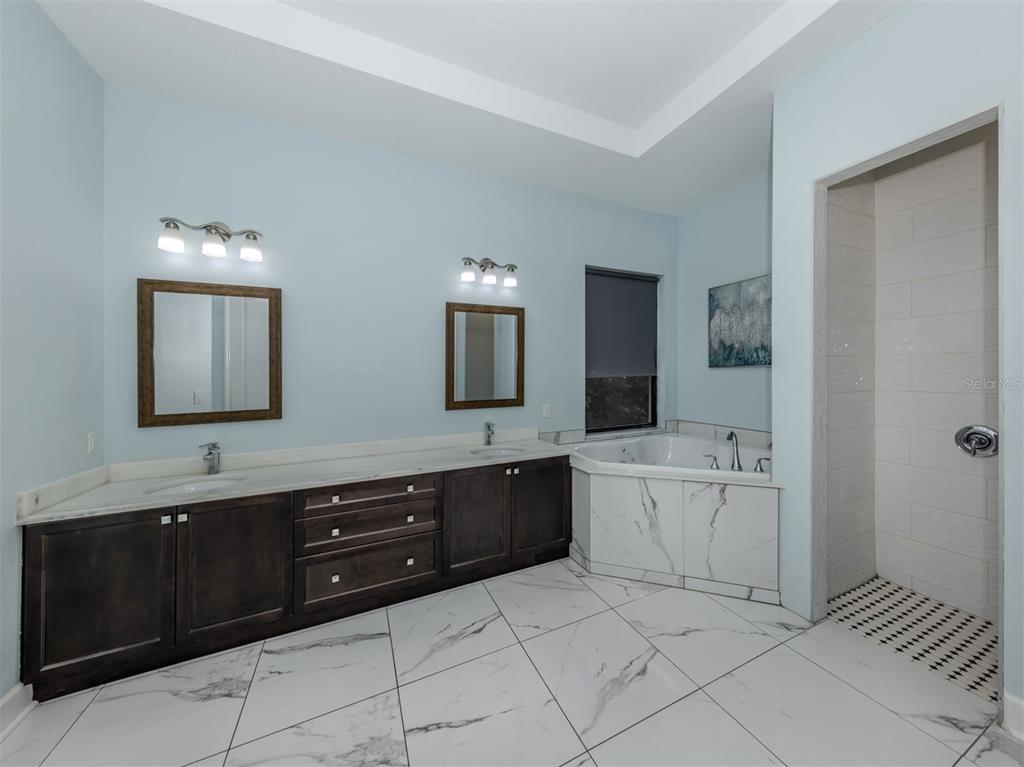 2107 Johannesberg Road North Port, FL 34288 - Photo 24 of 60 a spacious bathroom with a granite countertop sink mirror and bathtub
