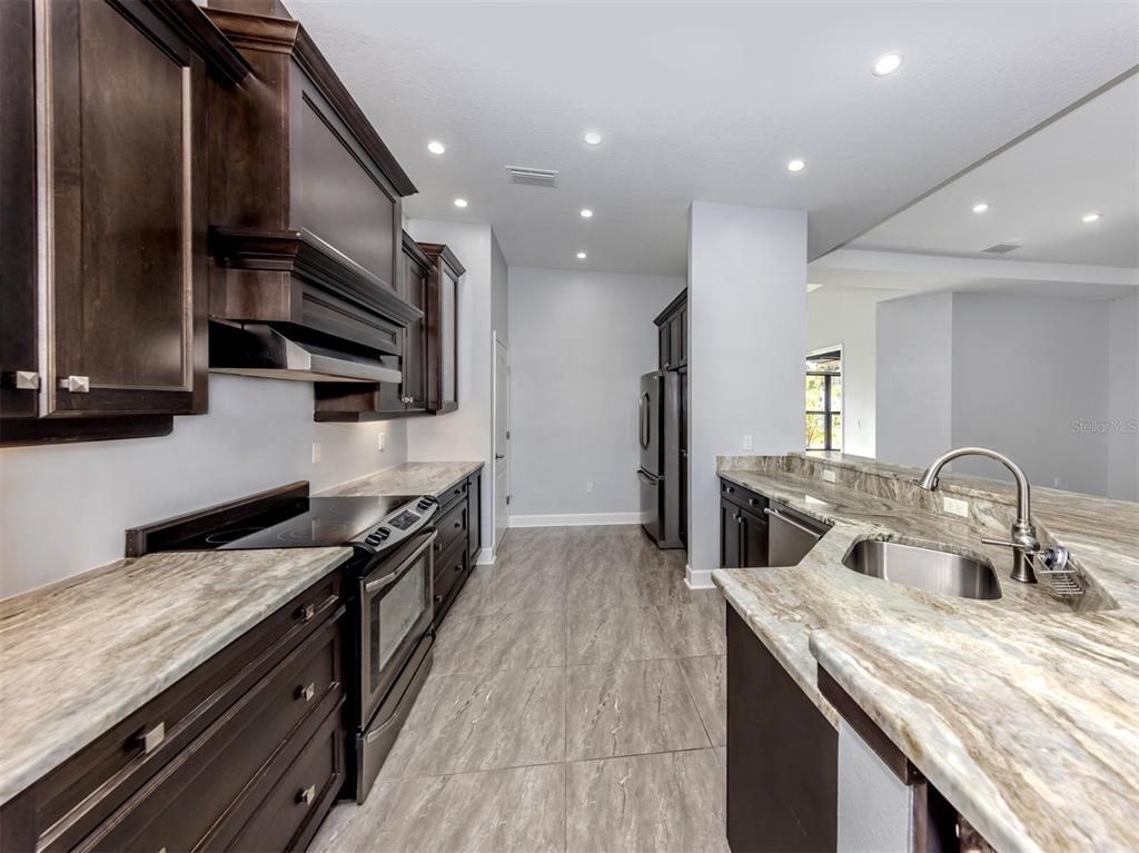 2107 Johannesberg Road North Port, FL 34288 - Photo 9 of 60 a kitchen with stainless steel appliances granite countertop a sink a stove and a wooden floors