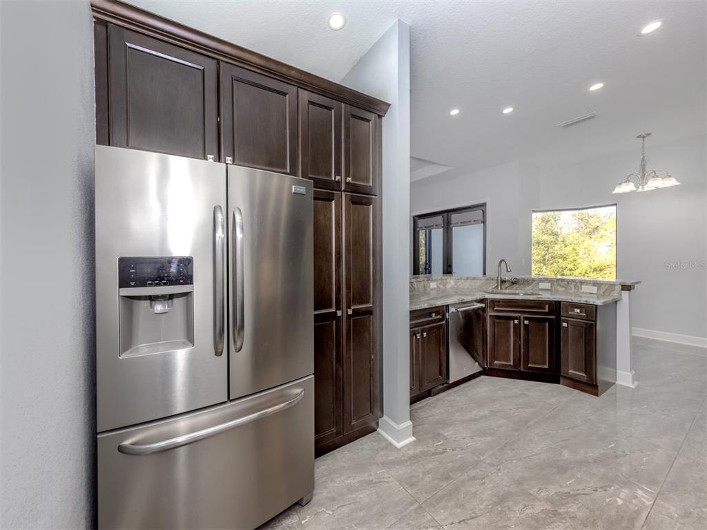 2107 Johannesberg Road North Port, FL 34288 - Photo 10 of 60 a metallic refrigerator freezer and a stove sitting inside of a kitchen