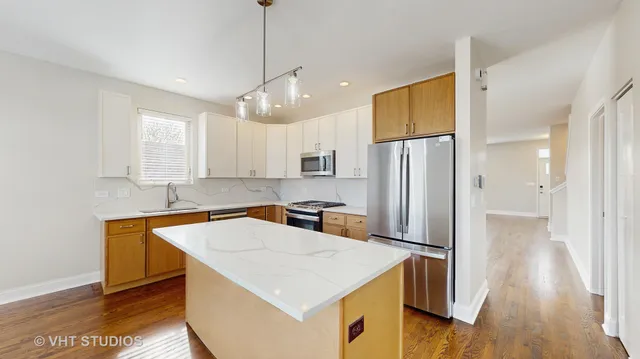 a kitchen with stainless steel appliances a refrigerator a sink a stove a microwave and island