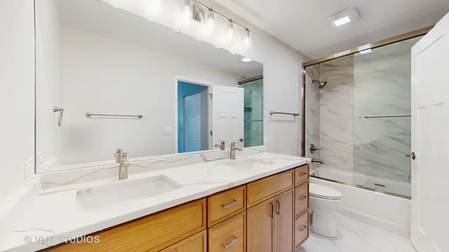 a bathroom with a shower sink vanity mirror and toilet