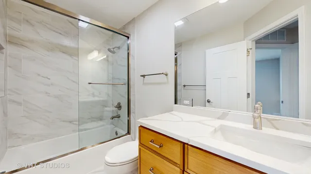 a bathroom with a granite countertop sink toilet and shower