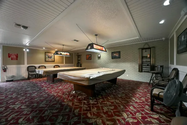 a living room with furniture pool table and a flat screen tv