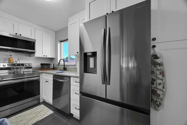a kitchen with stainless steel appliances a refrigerator sink and microwave
