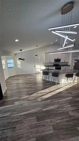 a kitchen with kitchen island a stove and a wooden floor