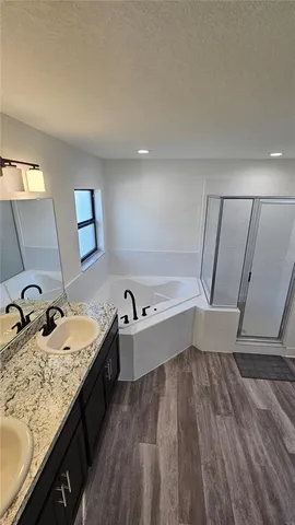 a bathroom with a granite countertop tub sink and mirror