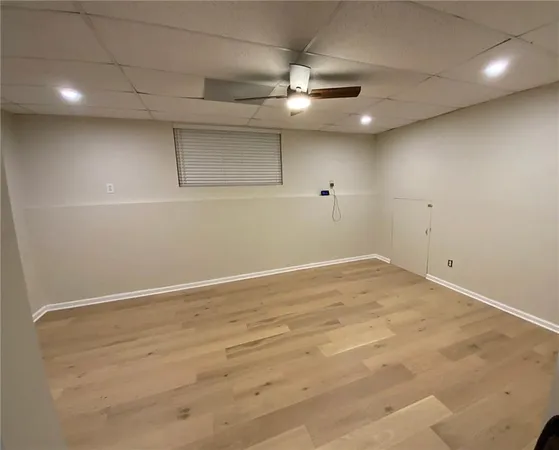 an empty room with a ceiling fan and window
