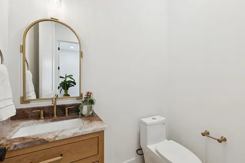 a bathroom with a toilet a sink and mirror