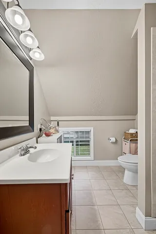 a bathroom with a sink a toilet and a mirror