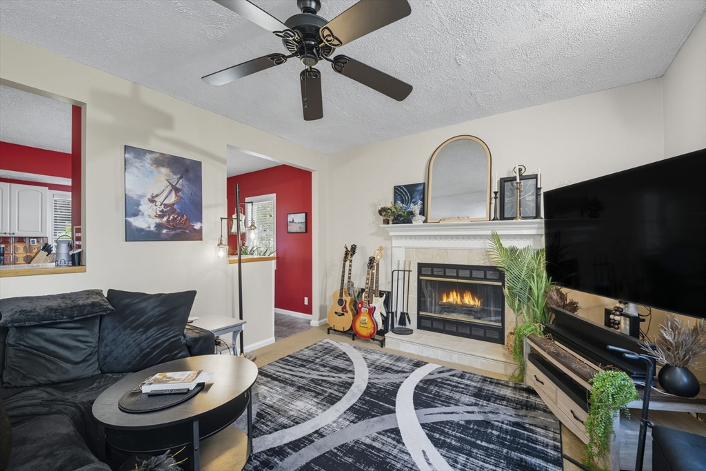 28 R School Street Danvers, MA 01923 - Photo 17 of 31 a living room with furniture a flat screen tv and a fireplace