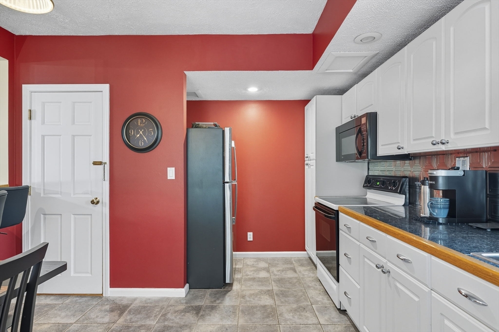 28 R School Street Danvers, MA 01923 - Photo 22 of 31 a kitchen with stainless steel appliances granite countertop a refrigerator a stove top oven a sink and dishwasher