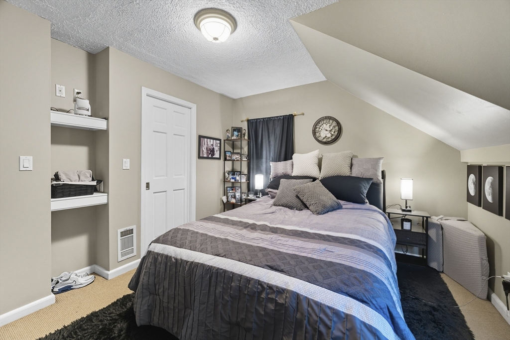 28 R School Street Danvers, MA 01923 - Photo 24 of 31 a bedroom with a bed and a lamp