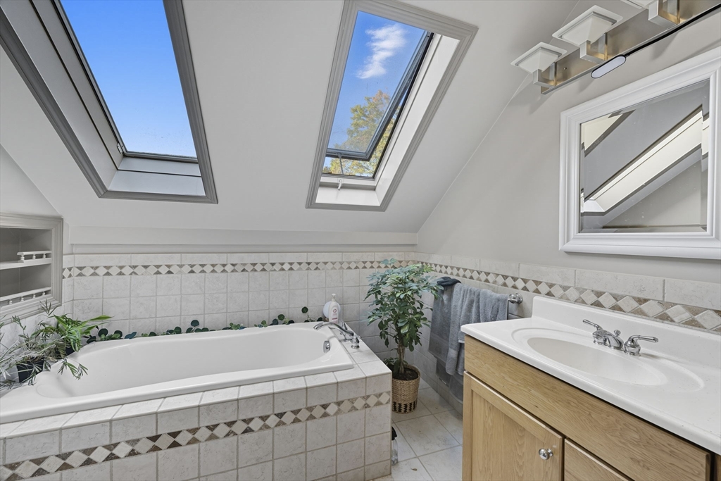28 R School Street Danvers, MA 01923 - Photo 25 of 31 a bathroom with a tub a sink and mirror