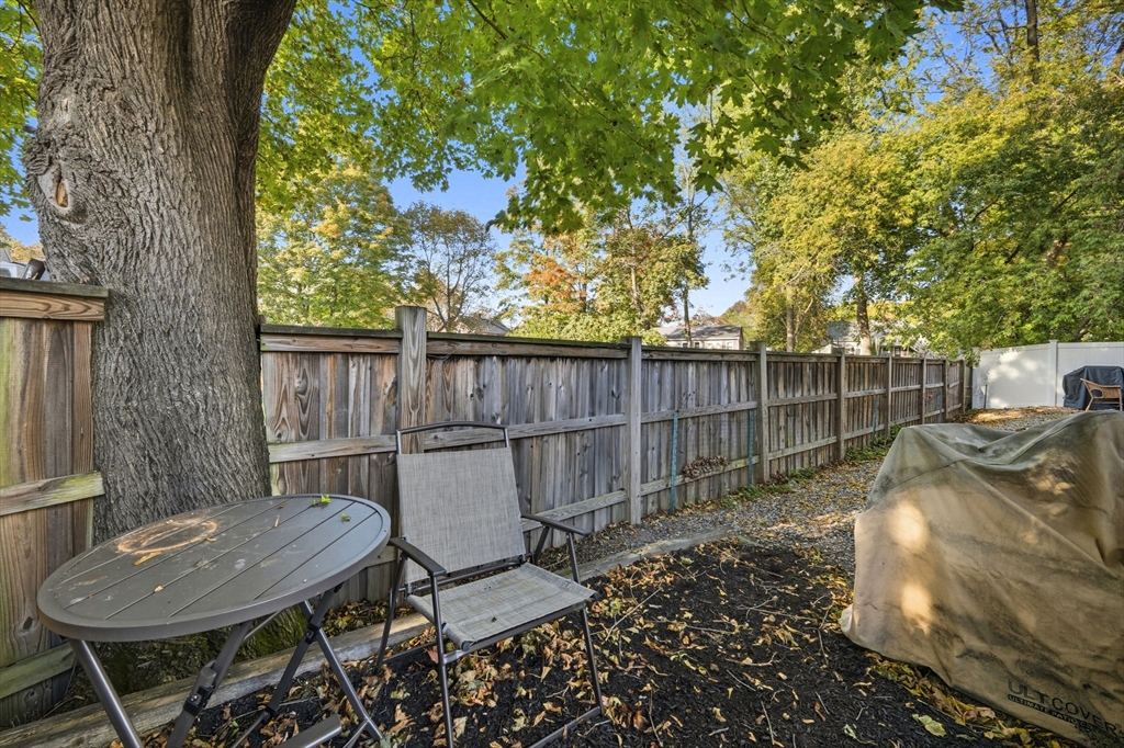 28 R School Street Danvers, MA 01923 - Photo 30 of 31 a view of a backyard with table and chairs potted plants and wooden fence