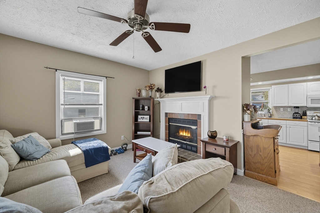 28 R School Street Danvers, MA 01923 - Photo 5 of 31 a living room with furniture a fireplace and a flat screen tv