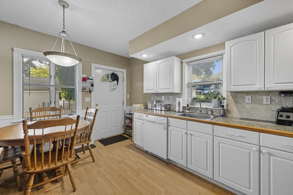 28 R School Street Danvers, MA 01923 - Photo 9 of 31 a kitchen with stainless steel appliances granite countertop a white cabinets and a chandelier