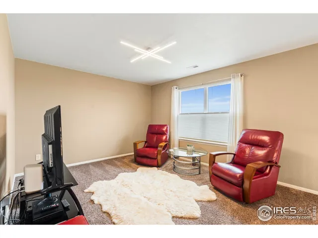 a spacious bedroom with a bed a couch and a large window