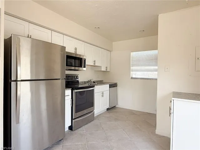 a kitchen with stainless steel appliances a refrigerator sink and microwave