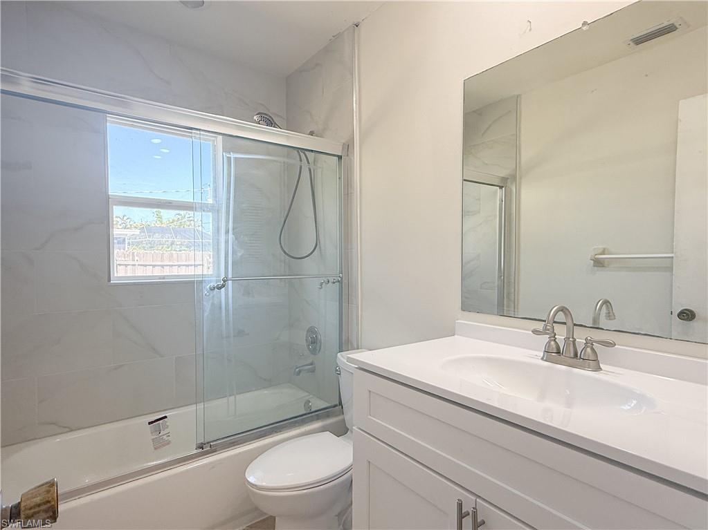593 92nd Avenue North, Unit A & B Naples, FL 34108 - Photo 5 of 6 a bathroom with a granite countertop sink a toilet and shower